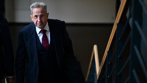 Hans-Georg Maaßen mit schwarzen Mantel kommt die Treppe hoch.
