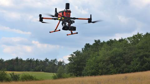 Eine Drohne mit Wärmebildkamera und Lautsprecher fliegt über einem Übungsgelände der Bundeswehr.