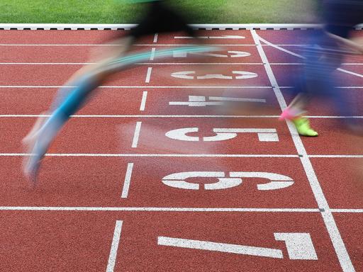 Zieleinlauf, bewegungsunscharfe Sprinter-Beine an der Ziellinie.