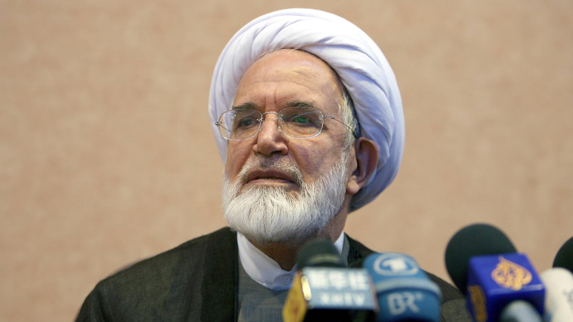 Der schiitische Oppositions- und Reformpolitiker Mehdi Karroubi sitzt vor Mikrofonen.