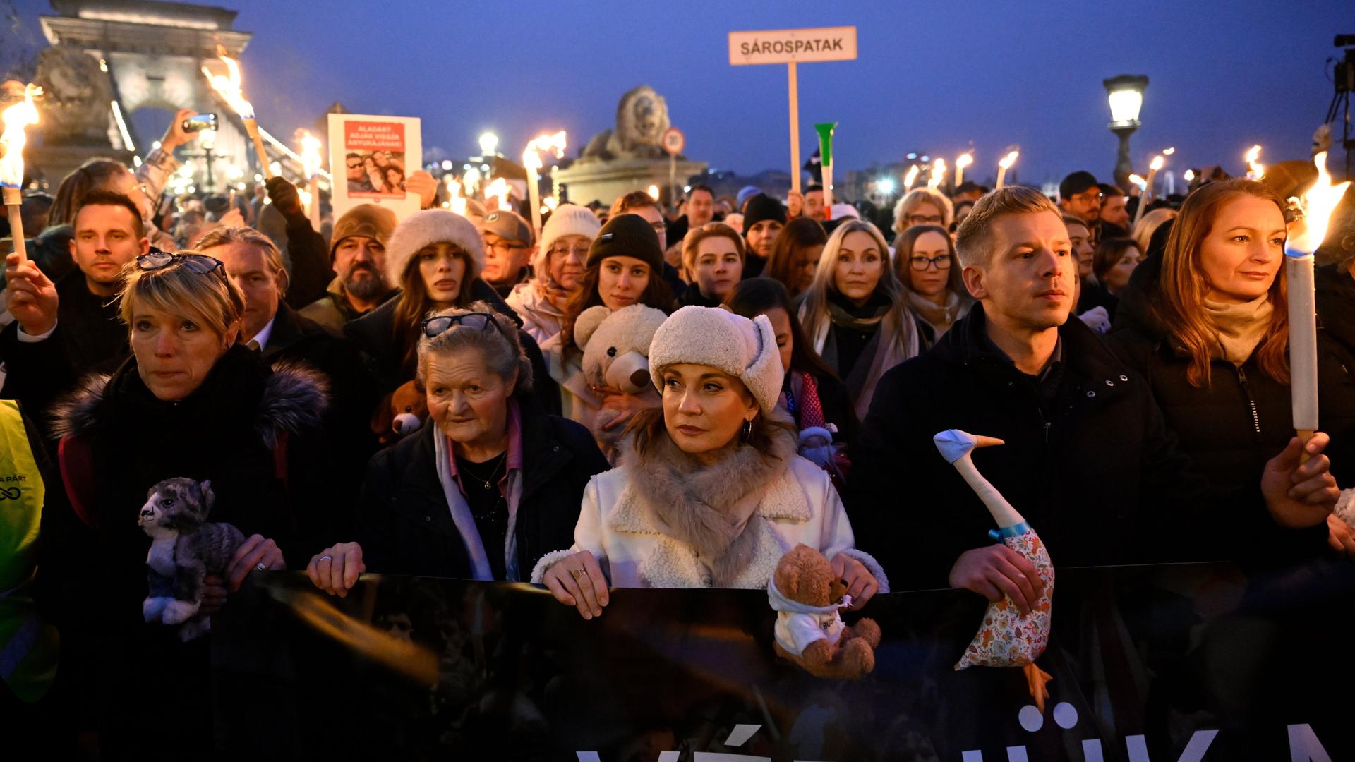Menschen stehen dicht gedrängt auf einer Demonstration und halten Schilder hoch. Menschen stehen dicht gedrängt auf einer Demonstration und halten Schilder hoch.