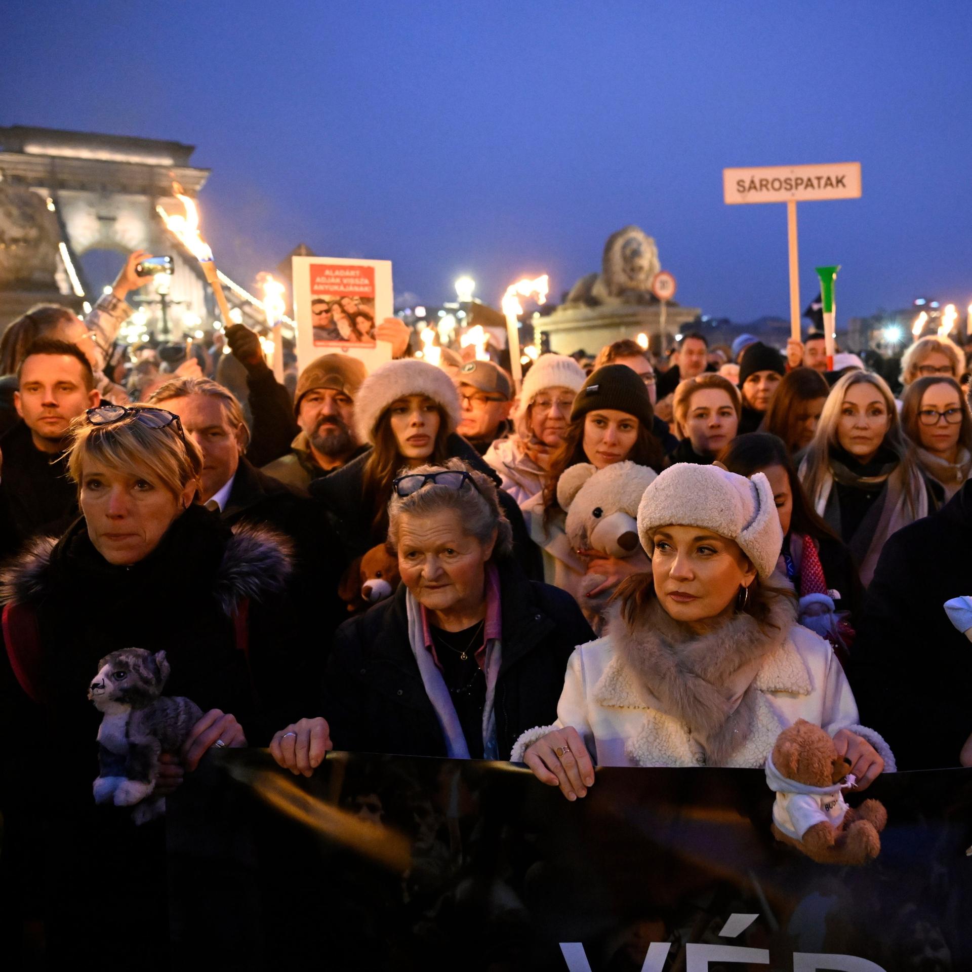 Menschen stehen dicht gedrängt auf einer Demonstration und halten Schilder hoch.