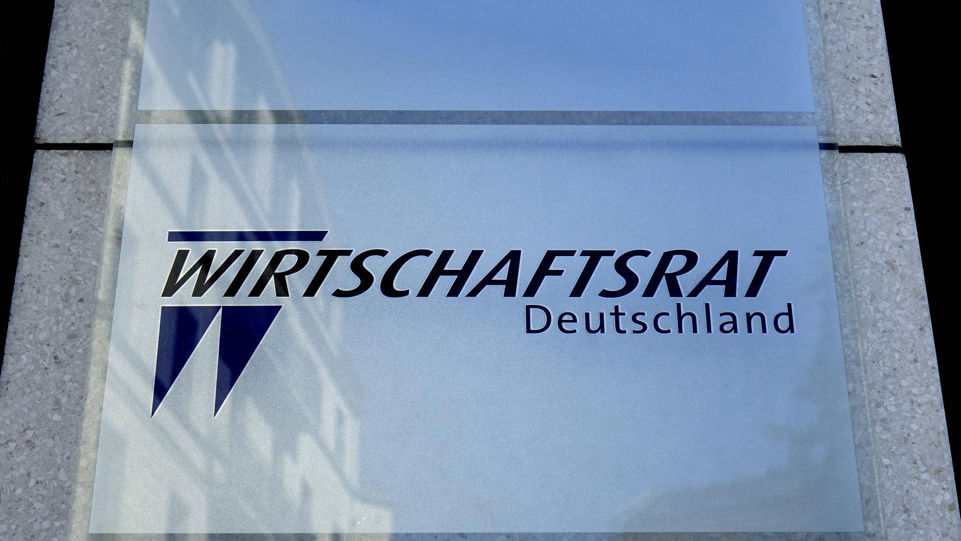 Das Bild zeigt das Logo des Wirtschaftsrats Deutschland. Der Schriftzug steht auf einer Glastafel, die an einer Fassade montiert ist.