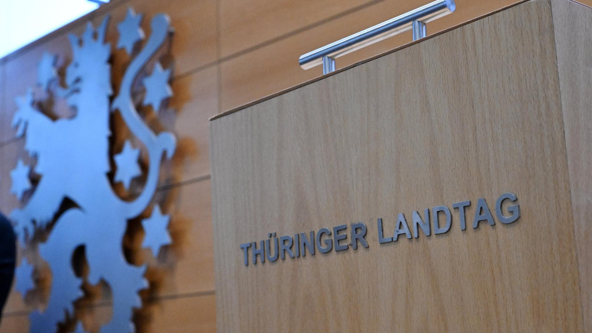 Eine Wahlurne mit der Aufschrift "Thüringer Landtag" steht neben dem Landeswappen im Plenarsaal während der Sitzung des Thüringer Landtags. 