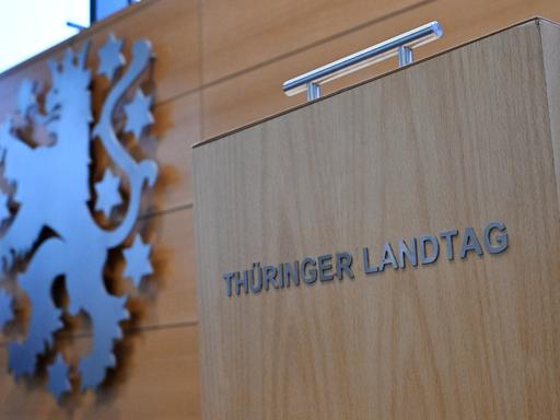 Eine Wahlurne mit der Aufschrift "Thüringer Landtag" steht neben dem Landeswappen im Plenarsaal während der Sitzung des Thüringer Landtags. 