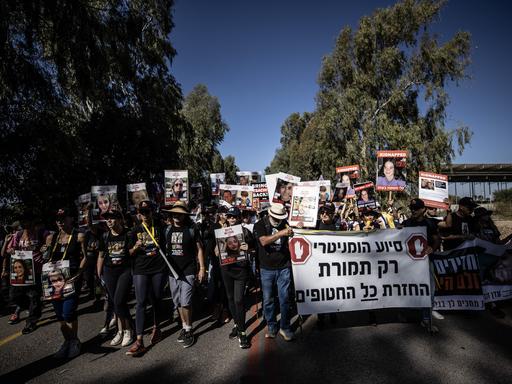 Angehörige israelischer Geiseln marschieren mit Transparenten in Richtung Jerusalem.