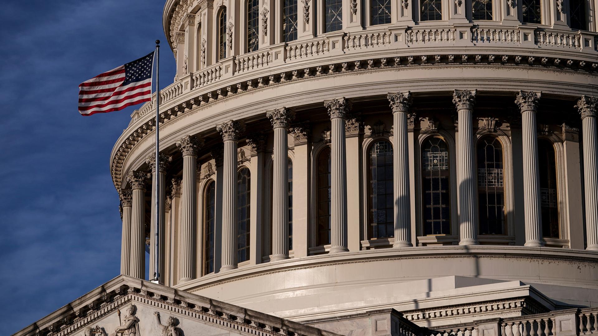 Das Foto zeigt das Kapitol in Washington mit einer US-Flagge