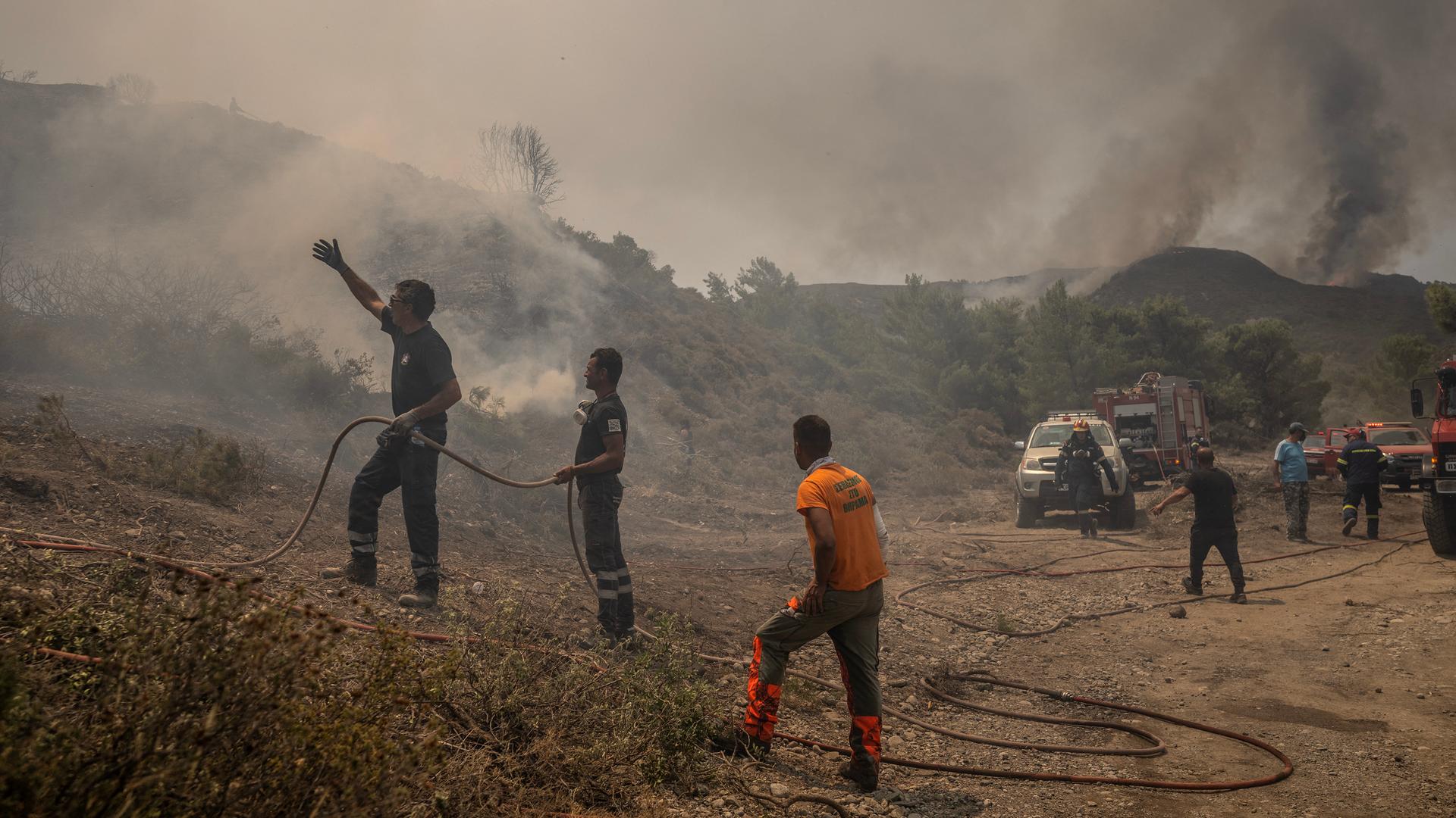Feuerwehrleute und Anwohner kämpfen auf Rhodos gegen die Flammen.
