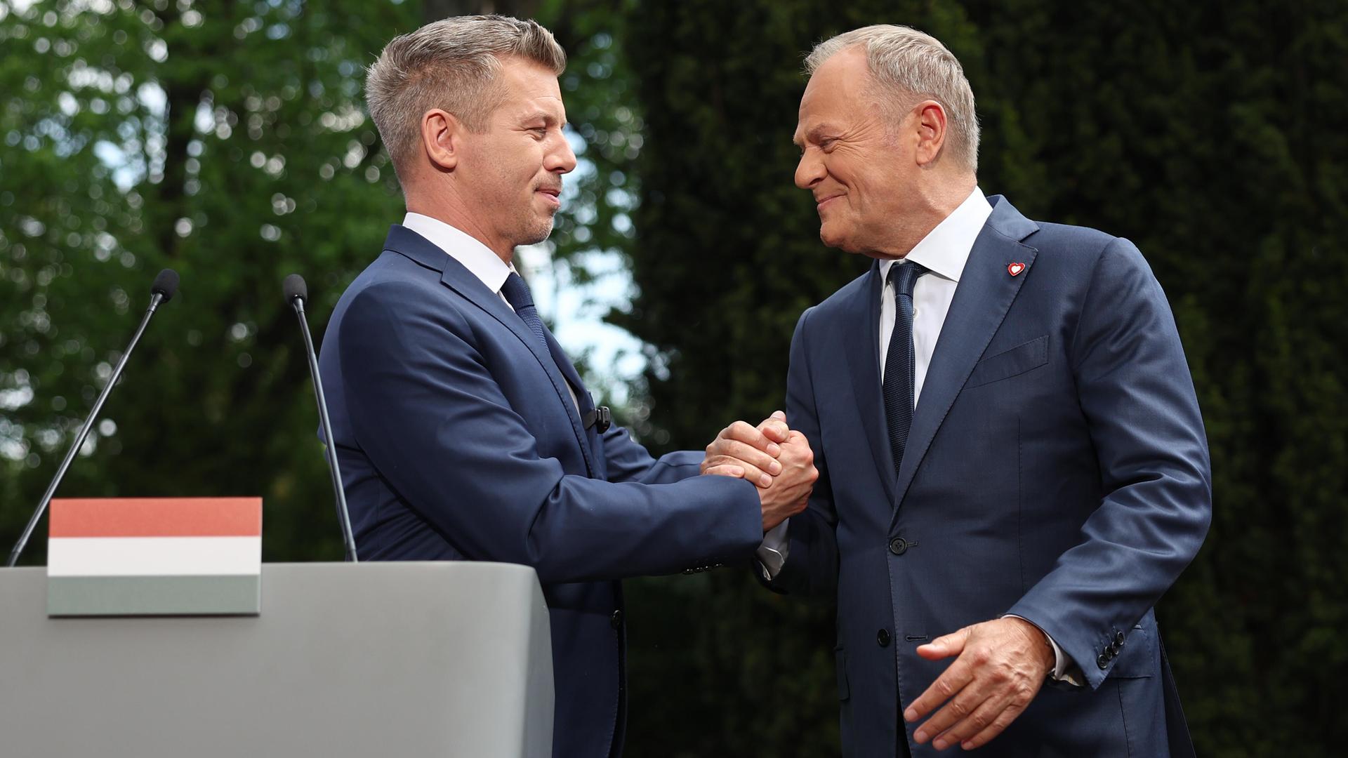 Ungarns Ministerpräsident Péter Magyar (links) und sein Amtskollege Donald Tusk bei einem herzlichen Händedruck in Warschau