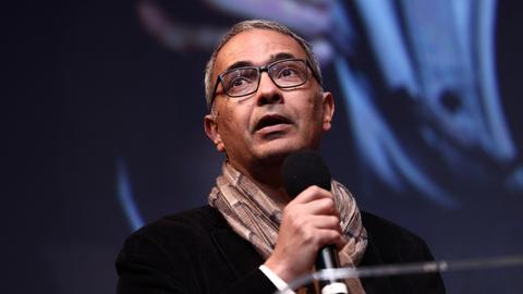 Kamel Daoud steht während einer Rede auf einer Bühne.