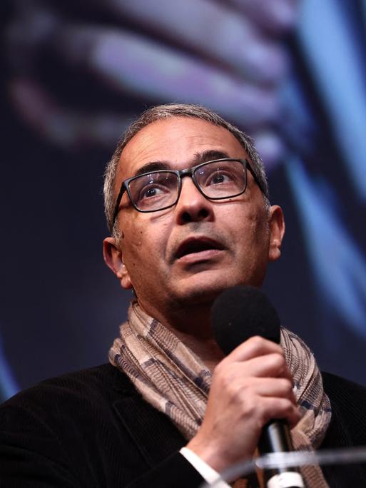 Kamel Daoud steht während einer Rede auf einer Bühne.