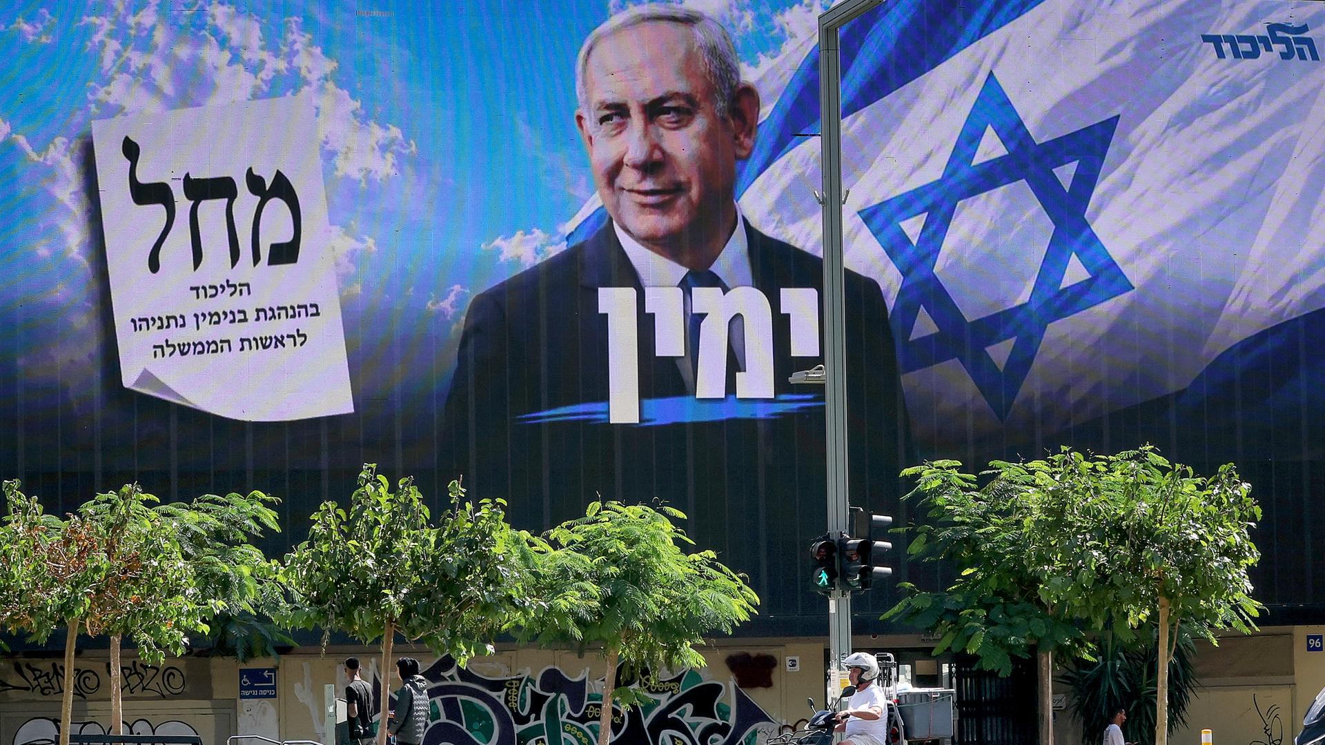 Ein Motorroller fährt in Tel Aviv an einer Plakatwand vorbei, auf der die Wahlwerbung von Premierminister Benjamin Netanjahu zu lesen ist.