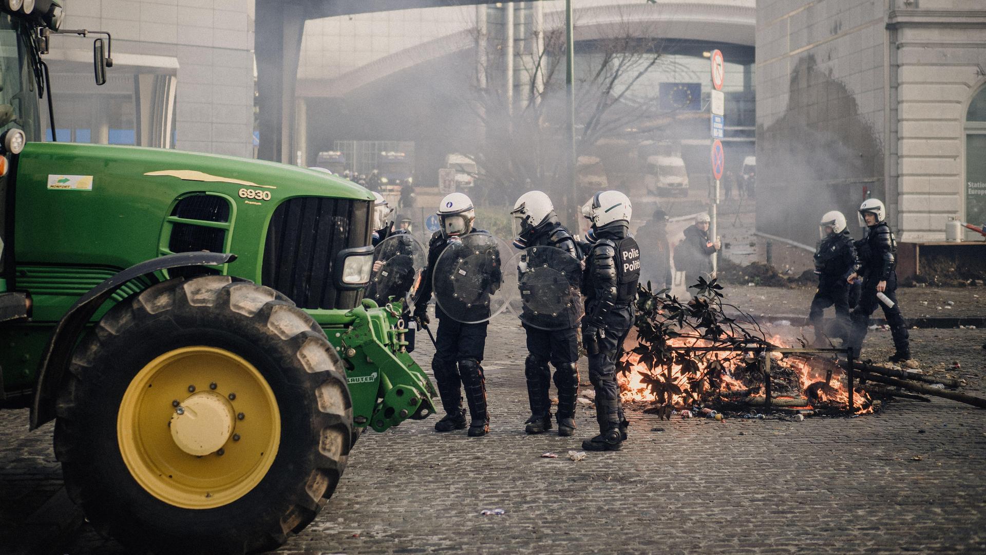 Ein Traktor steht vor dem Europäischen Parlament in Brüssel. Polizeikräfte sichern das Gelände.
