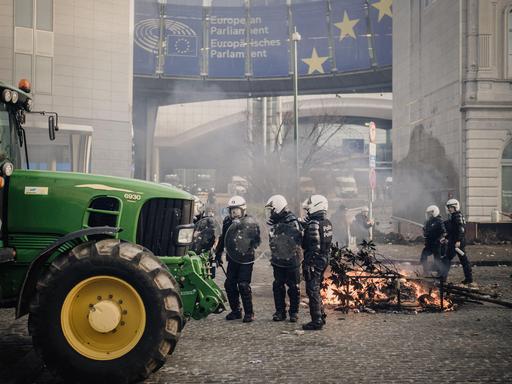 Ein Traktor steht vor dem Europäischen Parlament in Brüssel. Polizeikräfte sichern das Gelände.