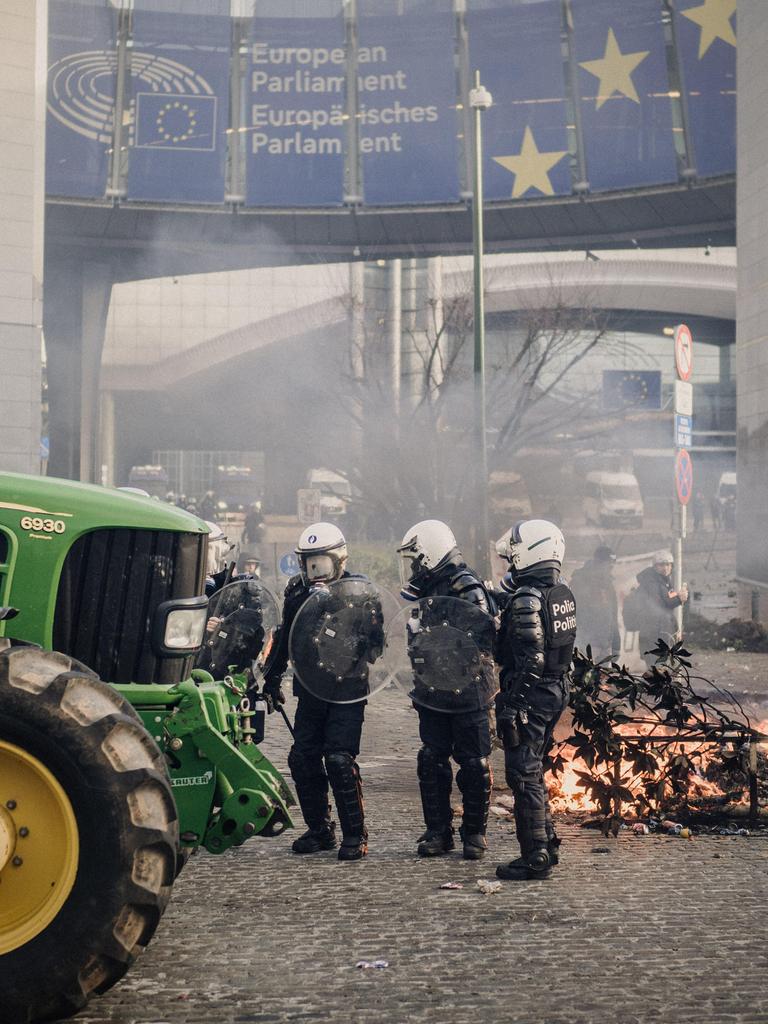 Ein Traktor steht vor dem Europäischen Parlament in Brüssel. Polizeikräfte sichern das Gelände.