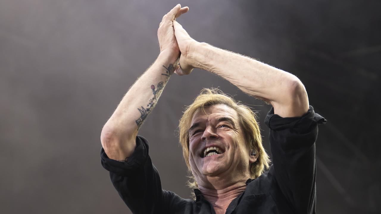 Campino steht bei einem Konzert auf der Bühne. Er klatscht und lacht.