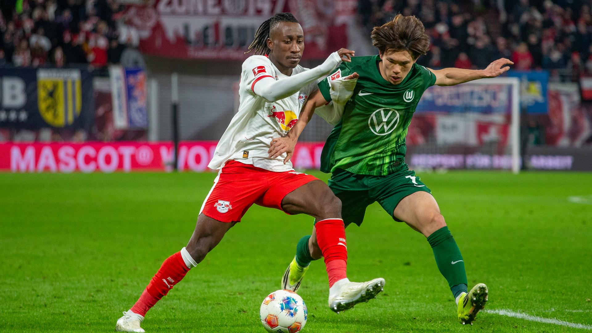 Das Bild zeigt eine Szene aus dem Bundesliga-Spiel Leipzig-Wolfsburg: Zweikampf des Leipzigers Yan Diomande (links) mit Wolfsburgs Kento Shiogai.