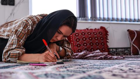 Eine junge Frau macht zu Hause in Herat ihre Englisch-Hausaufgaben, obwohl die Taliban Frauen ab dem zwölften Lebensjahr den Schulbesuch verboten haben. Eine junge Frau macht zu Hause in Herat ihre Englisch-Hausaufgaben, obwohl die Taliban Frauen ab dem zwölften Lebensjahr den Schulbesuch verboten haben.