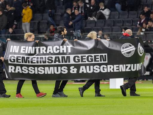 Bei einem Spiel der Fußball-Bundesliga in Frankfurt wird ein Banner gegen Rassismus und Ausgrenzung präsentiert.