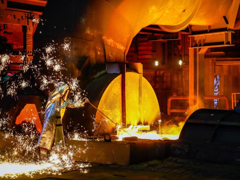 Stahlarbeiter im Schutzanzug arbeitet an einem Hochofen. Stahlarbeiter im Schutzanzug arbeitet an einem Hochofen.
