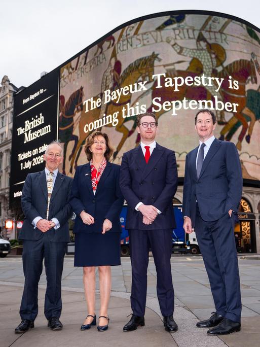 Der Direktor des British Museum, Dr Nicholas Cullinan, (3. v. links) mit weiteren Verantwortlichen vor einer Werbung für die Ausstellung ab September an einer Fassade am Picadilly Circus in London