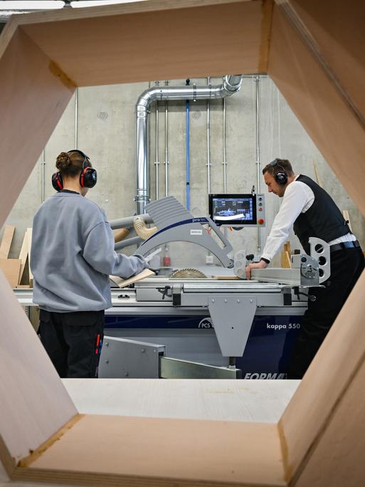 Ein Ausbildungsexperte der Berufsorientierung der Handwerkskammer Cottbus zeigt einer 14-jährigen Schülerin den Umgang mit einer Kreissäge im CreativeOpenLab (COLab) an der Brandenburgischen Technischen Universität Cottbus-Senftenberg (BTU).