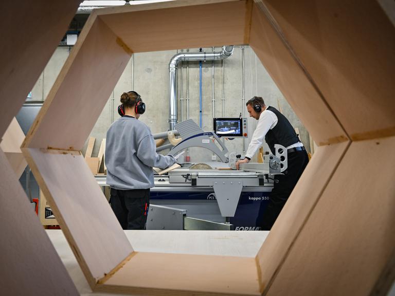 Ein Ausbildungsexperte der Berufsorientierung der Handwerkskammer Cottbus zeigt einer 14-jährigen Schülerin den Umgang mit einer Kreissäge im CreativeOpenLab (COLab) an der Brandenburgischen Technischen Universität Cottbus-Senftenberg (BTU).