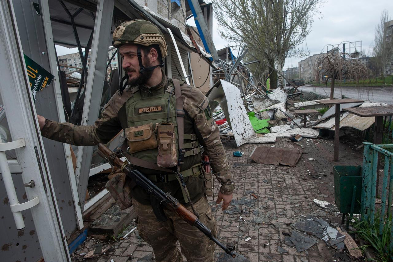 Ukraine, Bachmut: Ein ukrainischer Soldat steht vor einem zerstörten Haus. 
