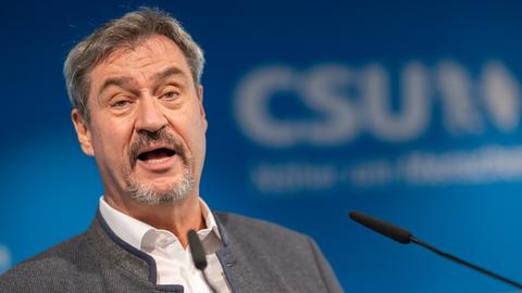 München: Markus Söder, Vorsitzender der CSU, spricht vor einem Mikrofon. Hinter ihm verschwommen der Schiftzug CSU.