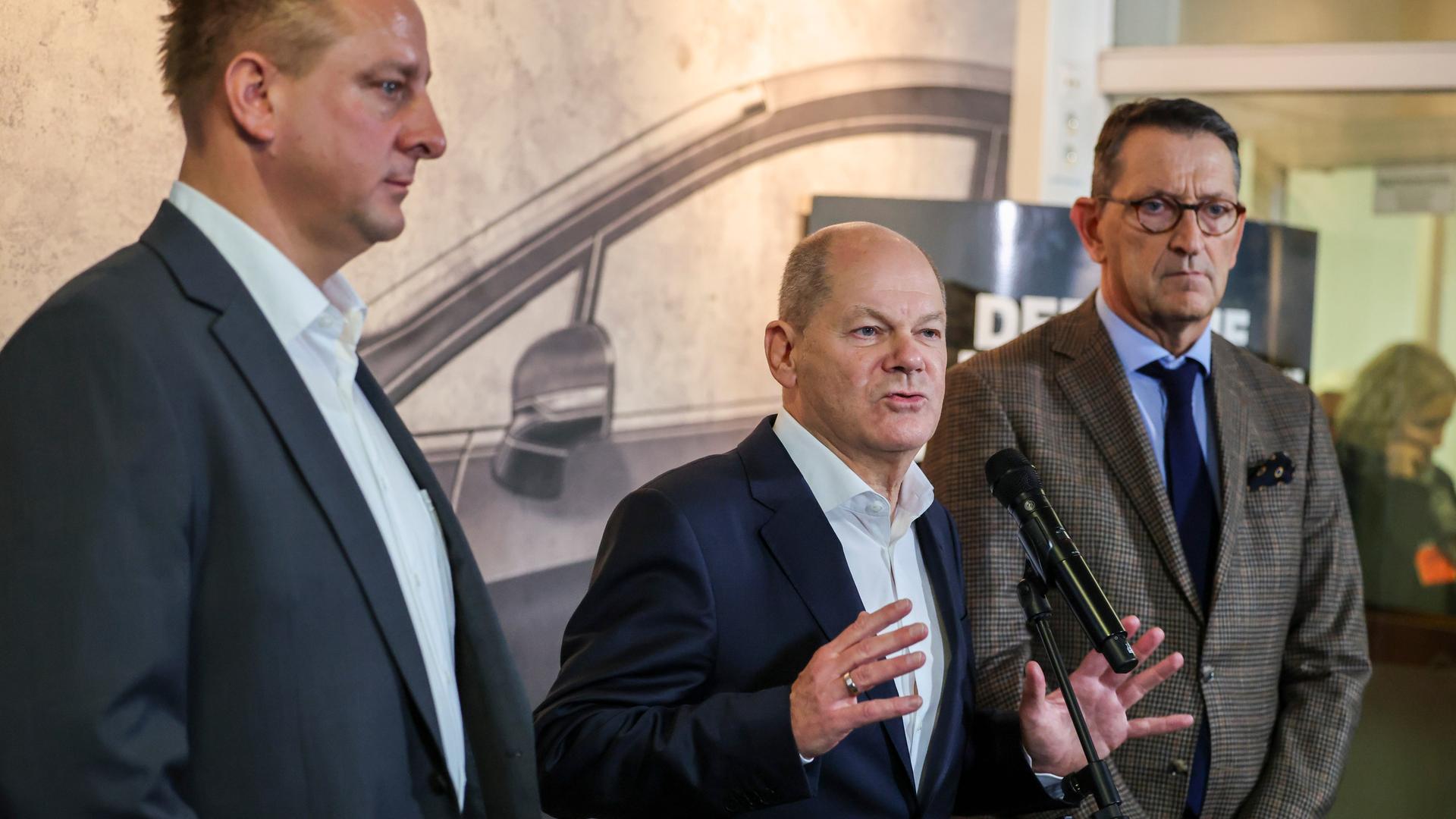 Benjamin Gruschka (l-r), Betriebsratschef Ford Deutschland, Bundeskanzler Olaf Scholz (SPD) und Marcus Wassenberg, Geschäftsführer der Ford Werke, sprechen am Rande der Betriebsversammlung mit Medienvertretern. 