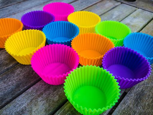 Farbige Silikon-Backformen für Muffins auf einem Holztisch. Silikon Backforrmencolored Silicone Back forms for Muffins on a Wooden table Silicone