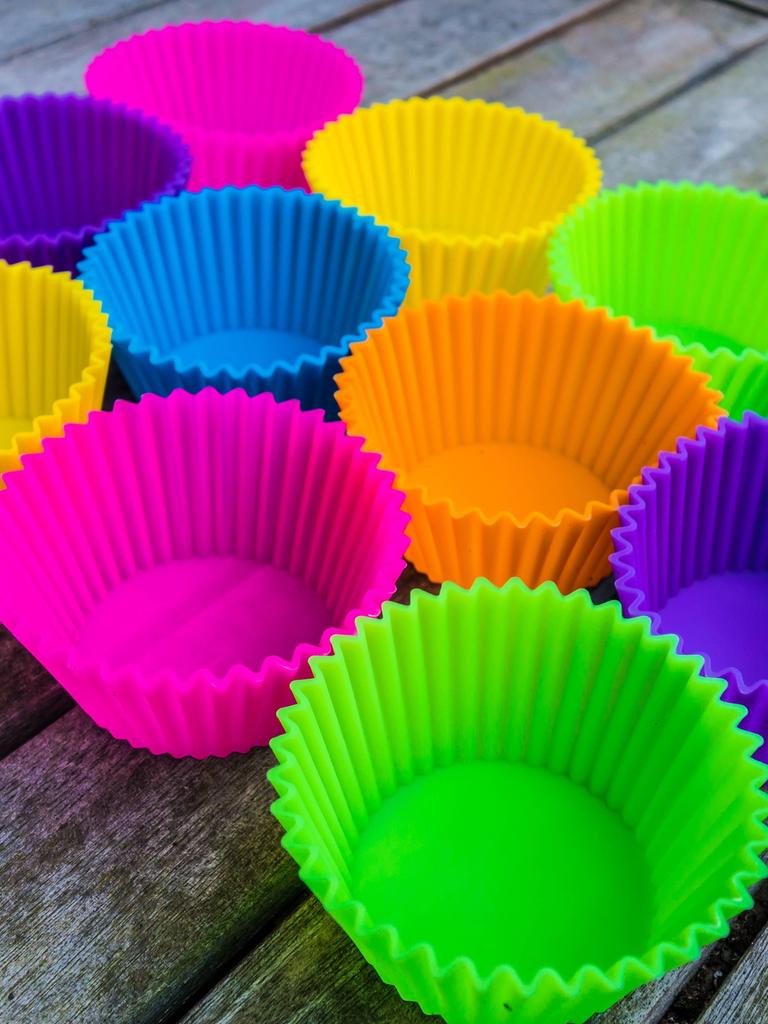 Farbige Silikon-Backformen für Muffins auf einem Holztisch. Silikon Backforrmencolored Silicone Back forms for Muffins on a Wooden table Silicone