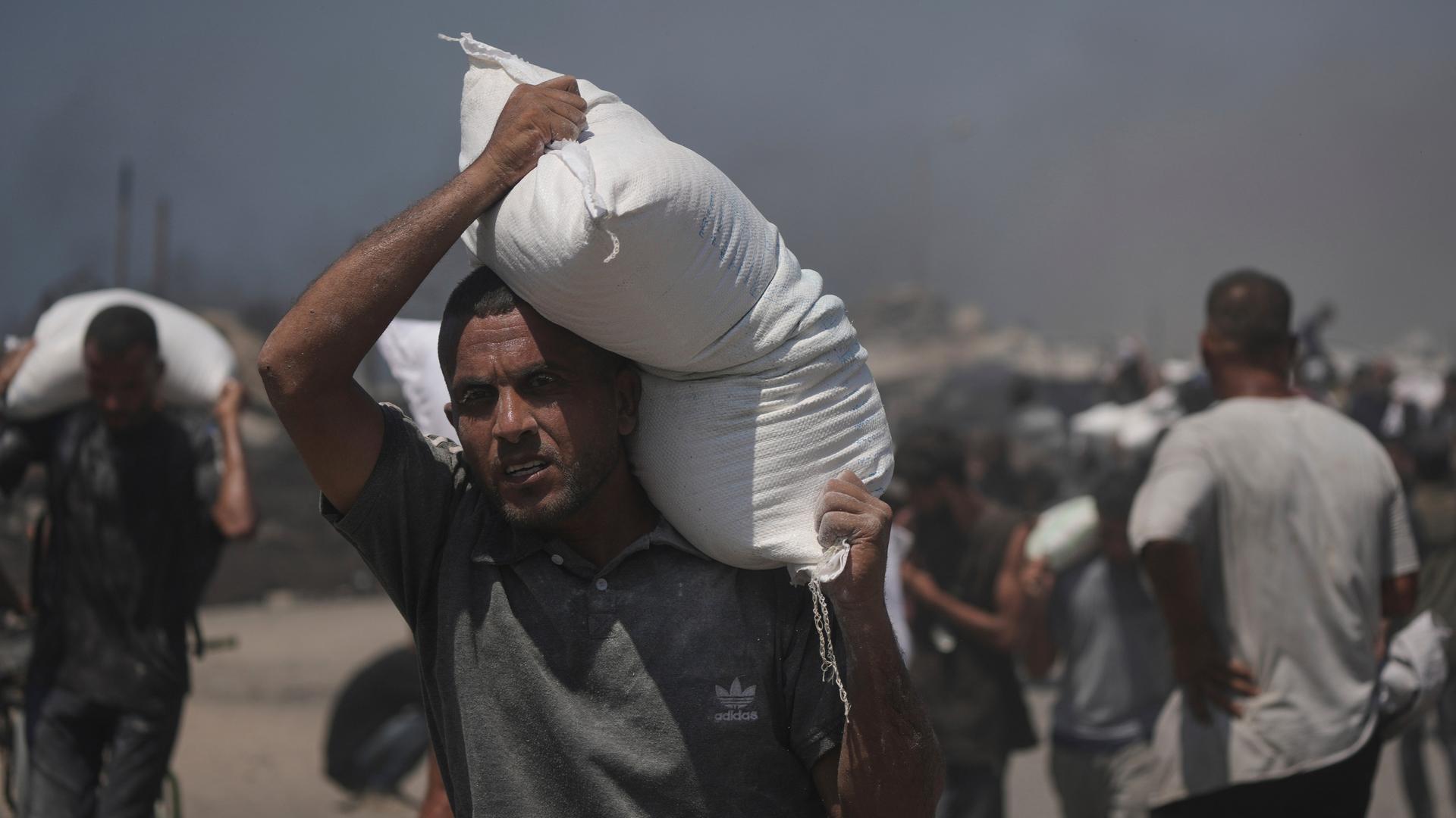 Ein Palästinenser in Gaza trägt einen Sack Mehl aus den Hilfslieferungen, die die Krisenregion erreichten. 