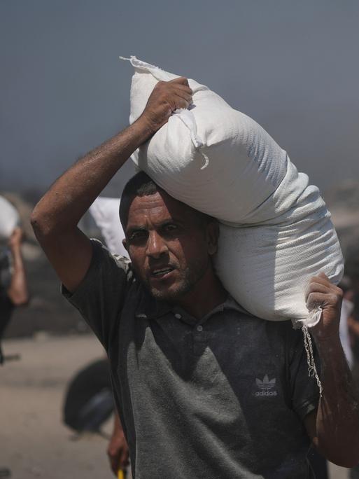 Ein Palästinenser in Gaza trägt einen Sack Mehl aus den Hilfslieferungen, die die Krisenregion erreichten. 