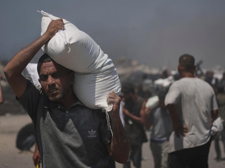 Ein Palästinenser in Gaza trägt einen Sack Mehl aus den Hilfslieferungen, die die Krisenregion erreichten. 