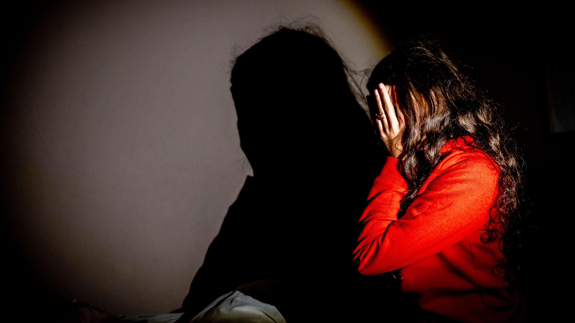 Eine junge Frau schlägt die Hände vors Gesicht. 