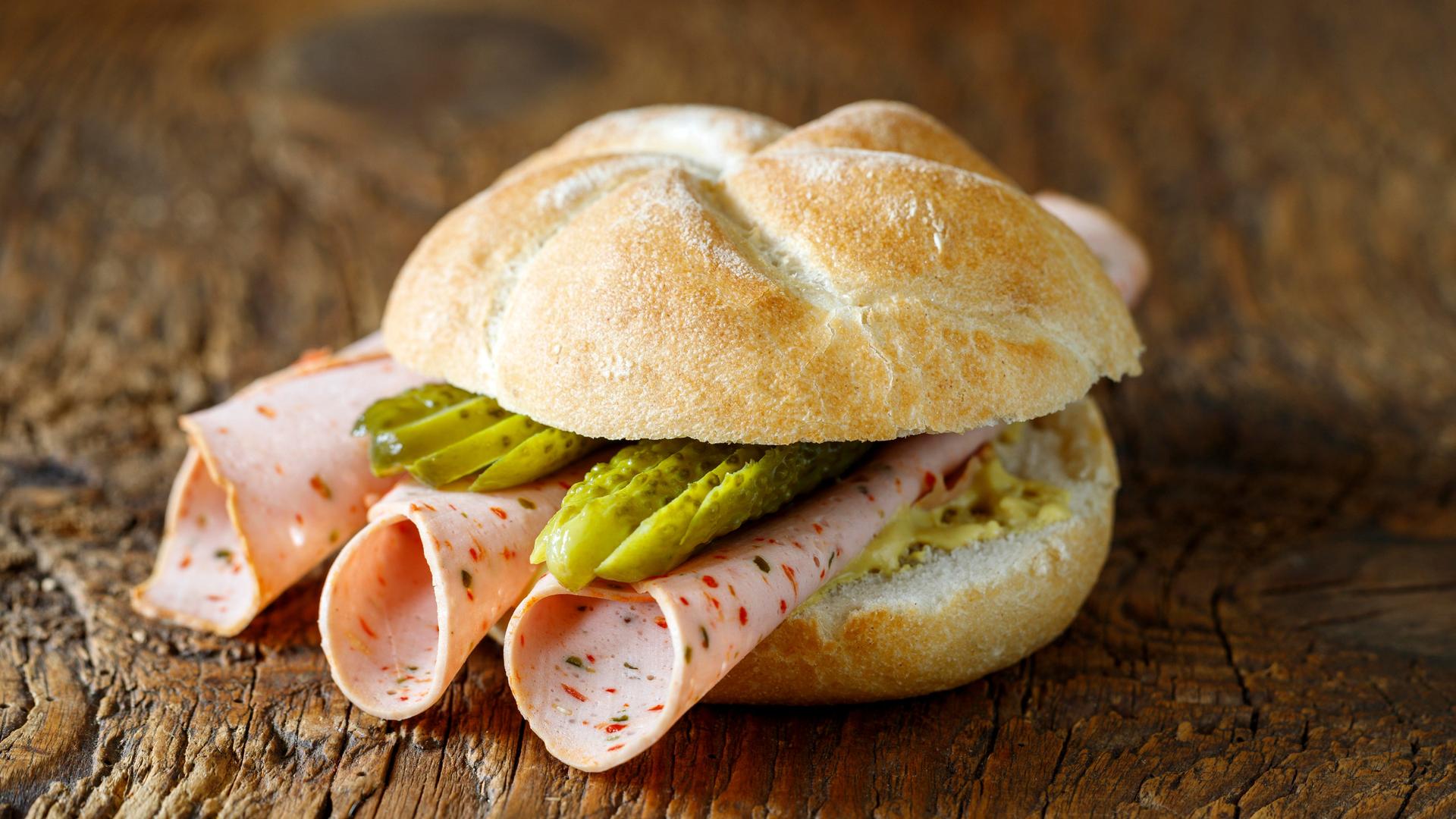 Belegtes Brötchen mit Wurst auf Holz Belegtes Brötchen mit Wurst auf Holz