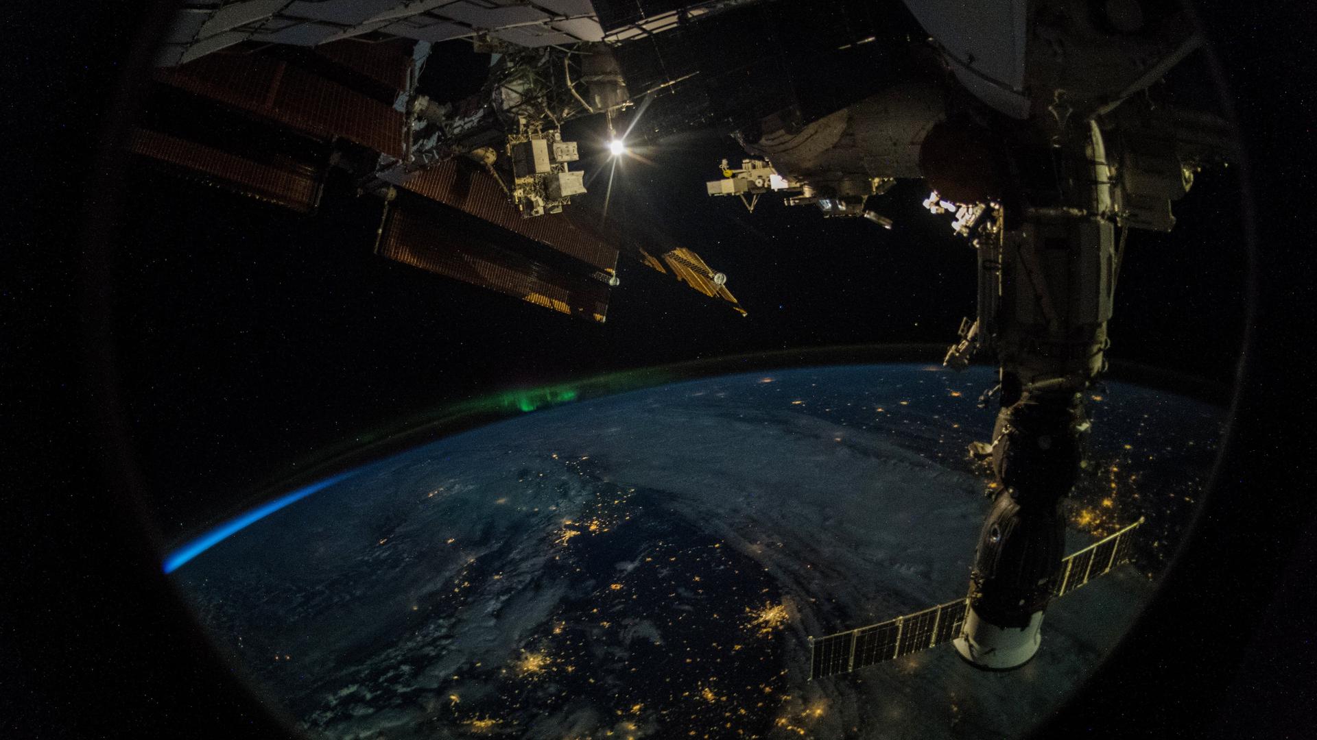 Die Erde gesehen von der ISS mit einem Satellitensystem im Vordergrund, Foto von Alexander Gerst, 2018.