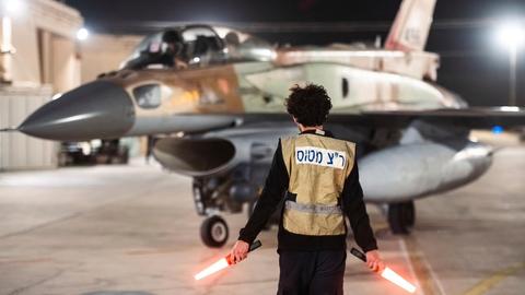 Ein Soldat der Israelischen Armee steht vor einem Militärflugzeug, das zu einem Angriff in den Iran aufbricht.