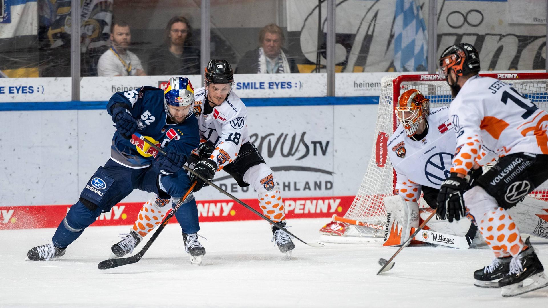 Spieler des EHC Red Bull München und der Grizzlys Wolfsburg kämpfen um den Puck.