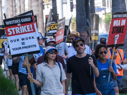 In Hollywood demonstrieren Drehbuchschreiber mit Plakaten in der Hand vor den Sunset Bronson studios in Los Angeles gegen Sparmaßnahmen der Filmbranche.