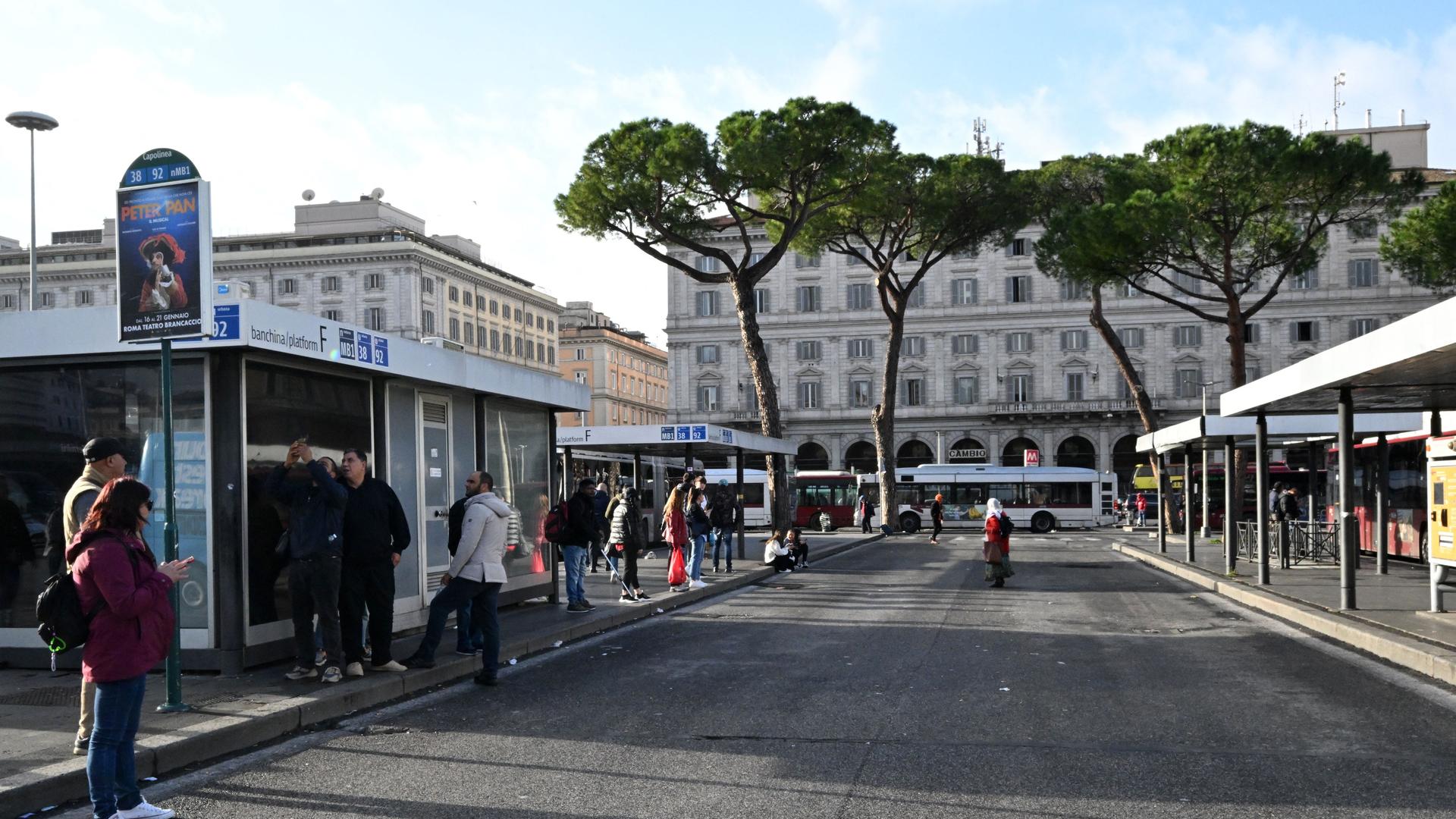 Menschen warten am Bahnhof Termini in Rom auf Busse.