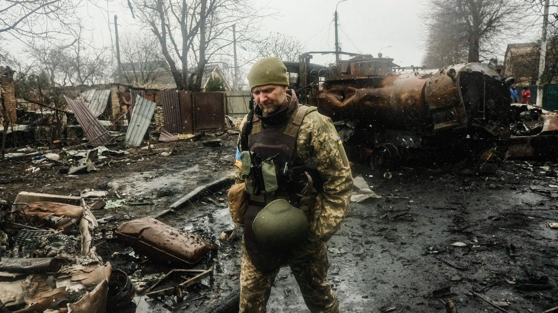 Ukrainische Soldaten inspizieren das Wrack einer zerstörten russischen Panzerkolonne auf einer Straße in Butscha, einem Vorort nördlich der Hauptstadt Kiew. 