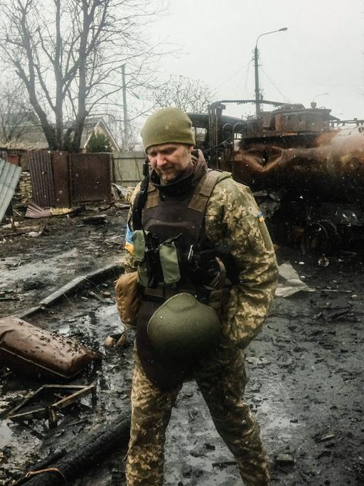 Ukrainische Soldaten inspizieren das Wrack einer zerstörten russischen Panzerkolonne auf einer Straße in Butscha, einem Vorort nördlich der Hauptstadt Kiew. 