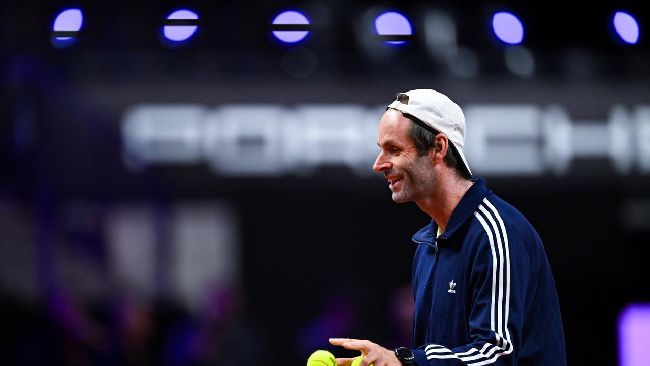 Torben Beltz von der Seite. Er lächelt und hat zwei Tennisbälle in der Hand. 