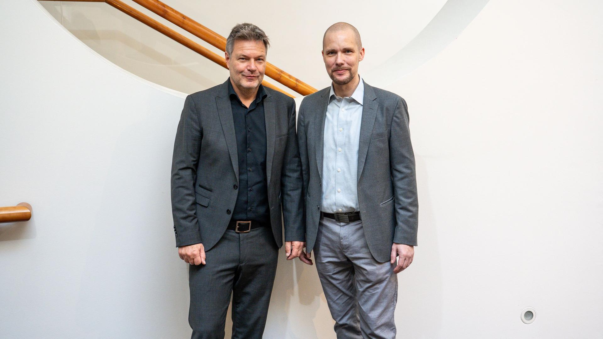 Bundeswirtschaftsminister Robert Habeck (l, Bündnis 90/Die Grünen) und Jonas Andrulis, Gründer des KI Unternehmens Aleph Alpha, stehen zusammen.