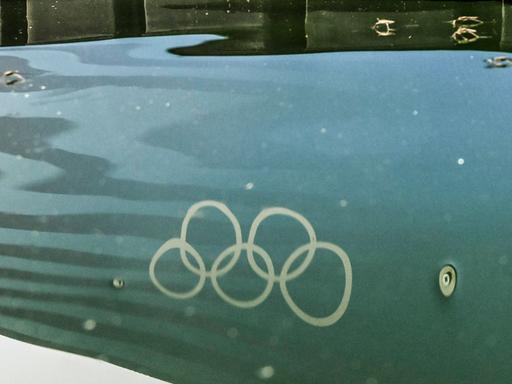 Die Olympischen Ringe spiegeln sich im Wasser der Seine.