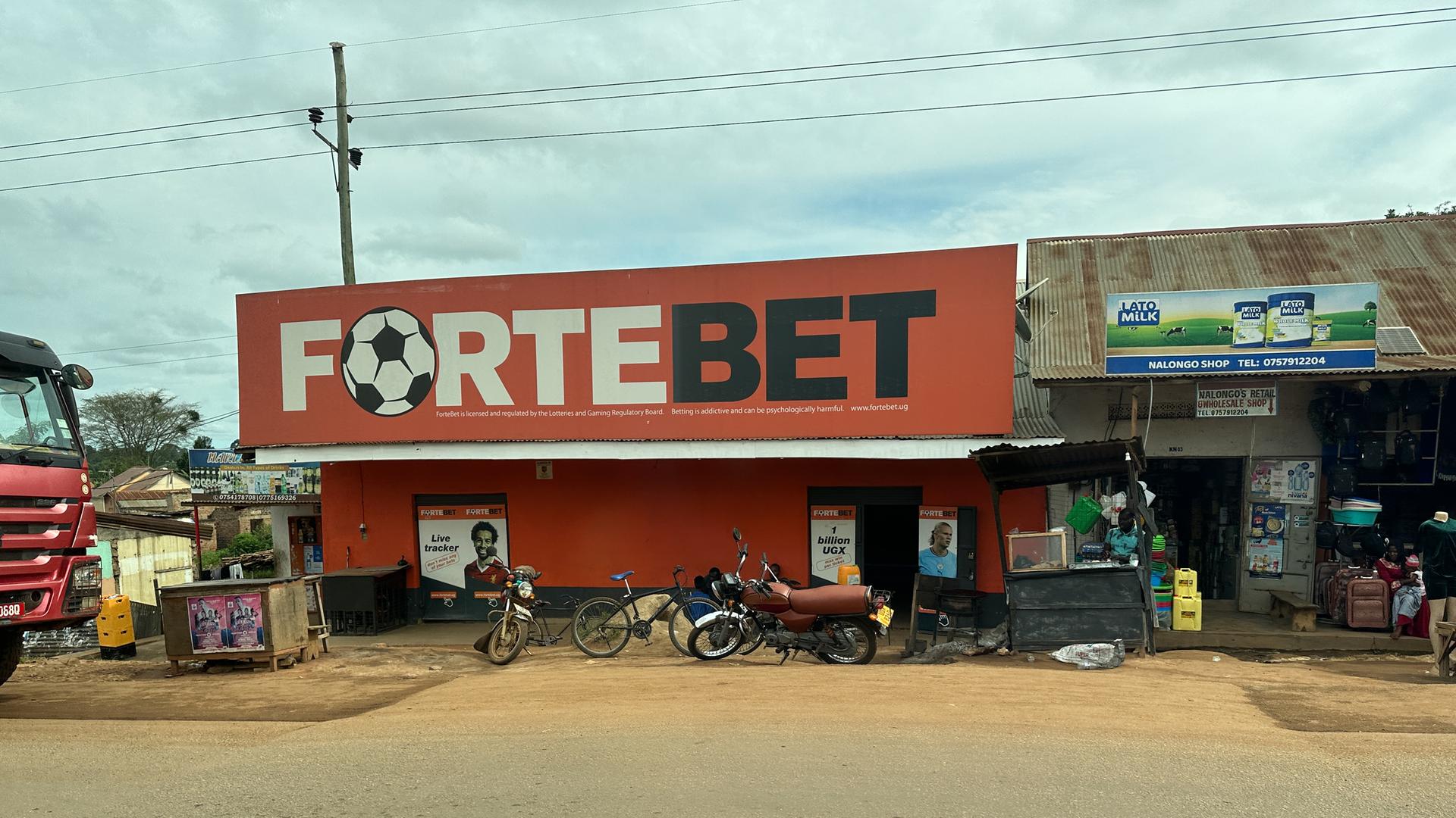 Über einem Haus prangt ein Schild mit einem Fußball und der Aufschrift "Fortebet".