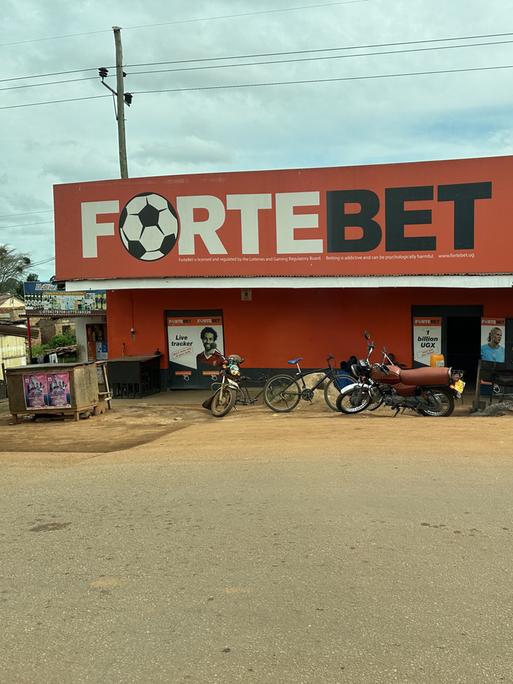 Über einem Haus prangt ein Schild mit einem Fußball und der Aufschrift "Fortebet".