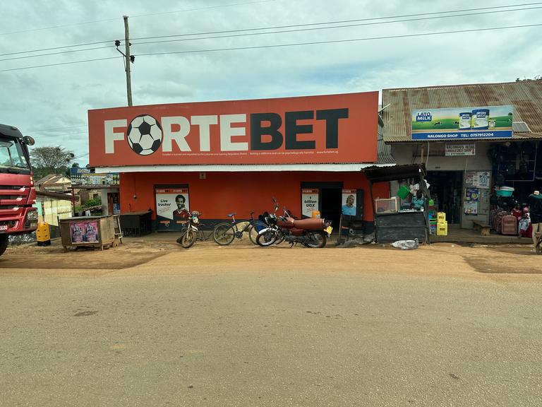 Über einem Haus prangt ein Schild mit einem Fußball und der Aufschrift "Fortebet".